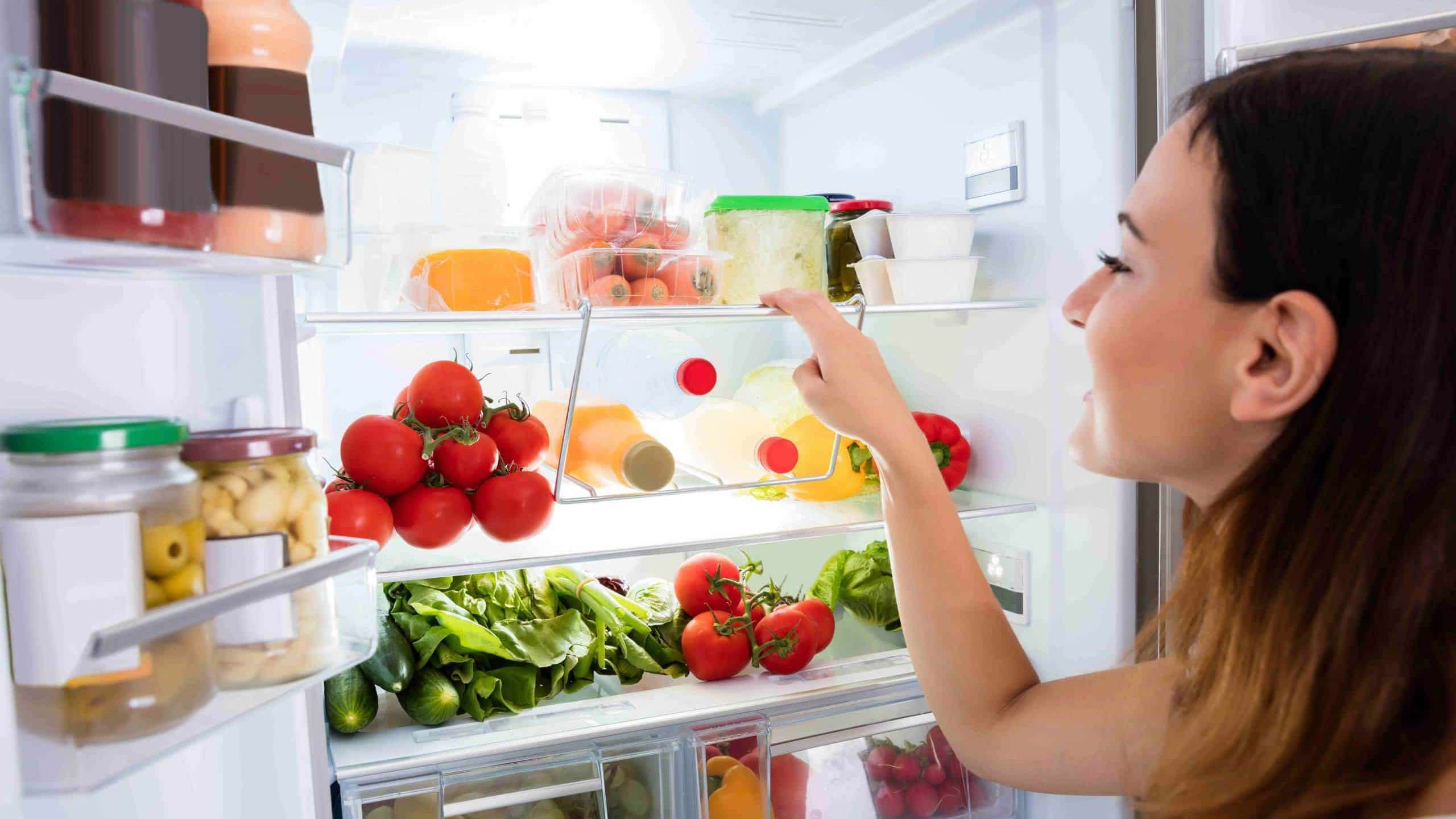 Une femme fait l'inventaire de son frigo