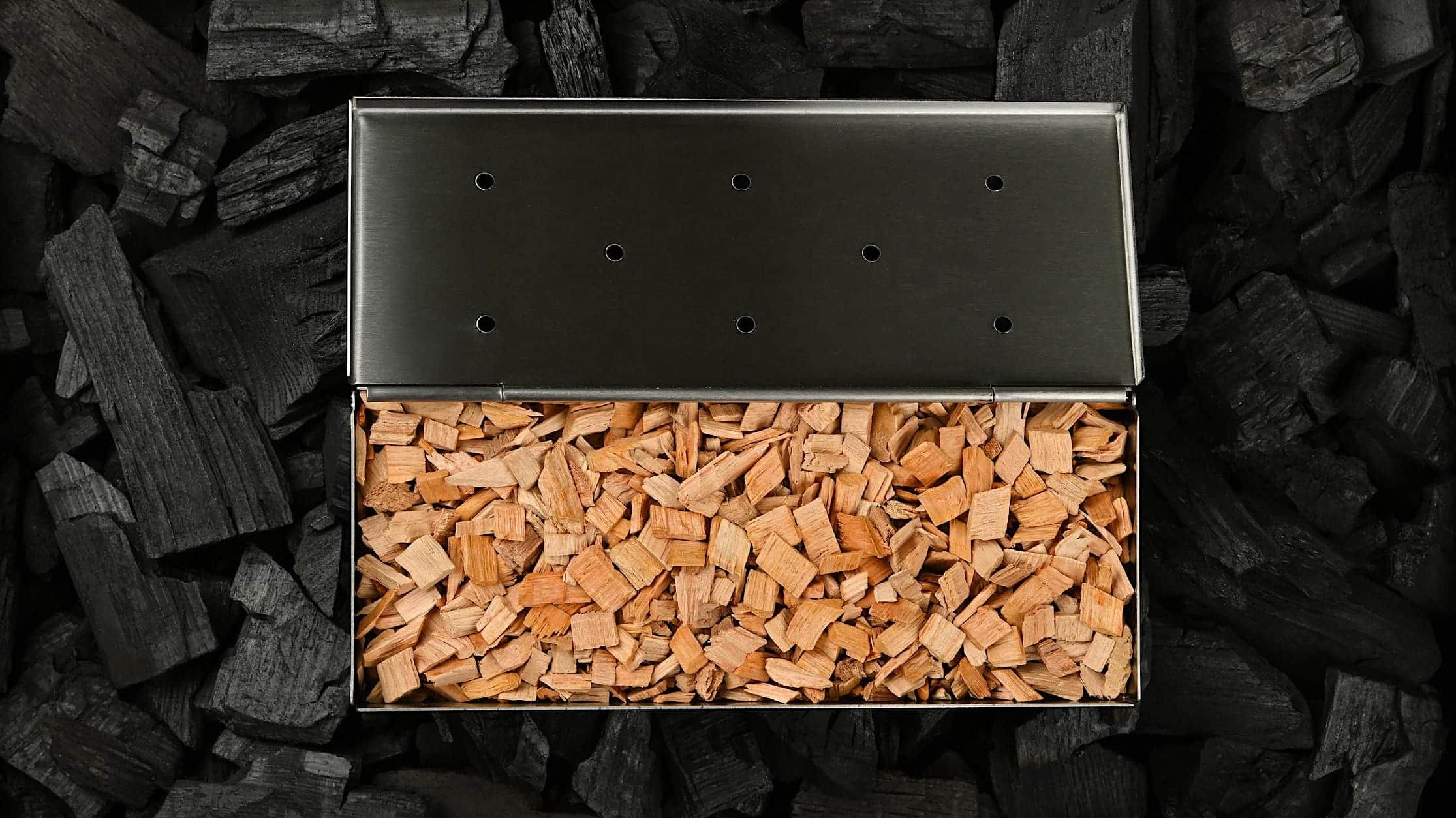 Une boite fumoir pour BBQ remplie de copeaux de bois