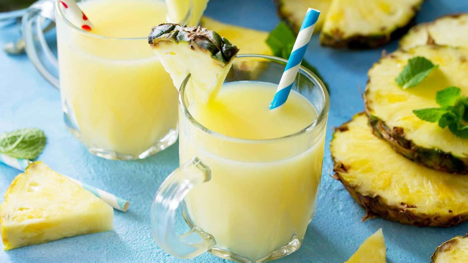 Des tasses de verre remplies de Pina Colada glacé, garnis d'une paille et d'un quartier d'ananas