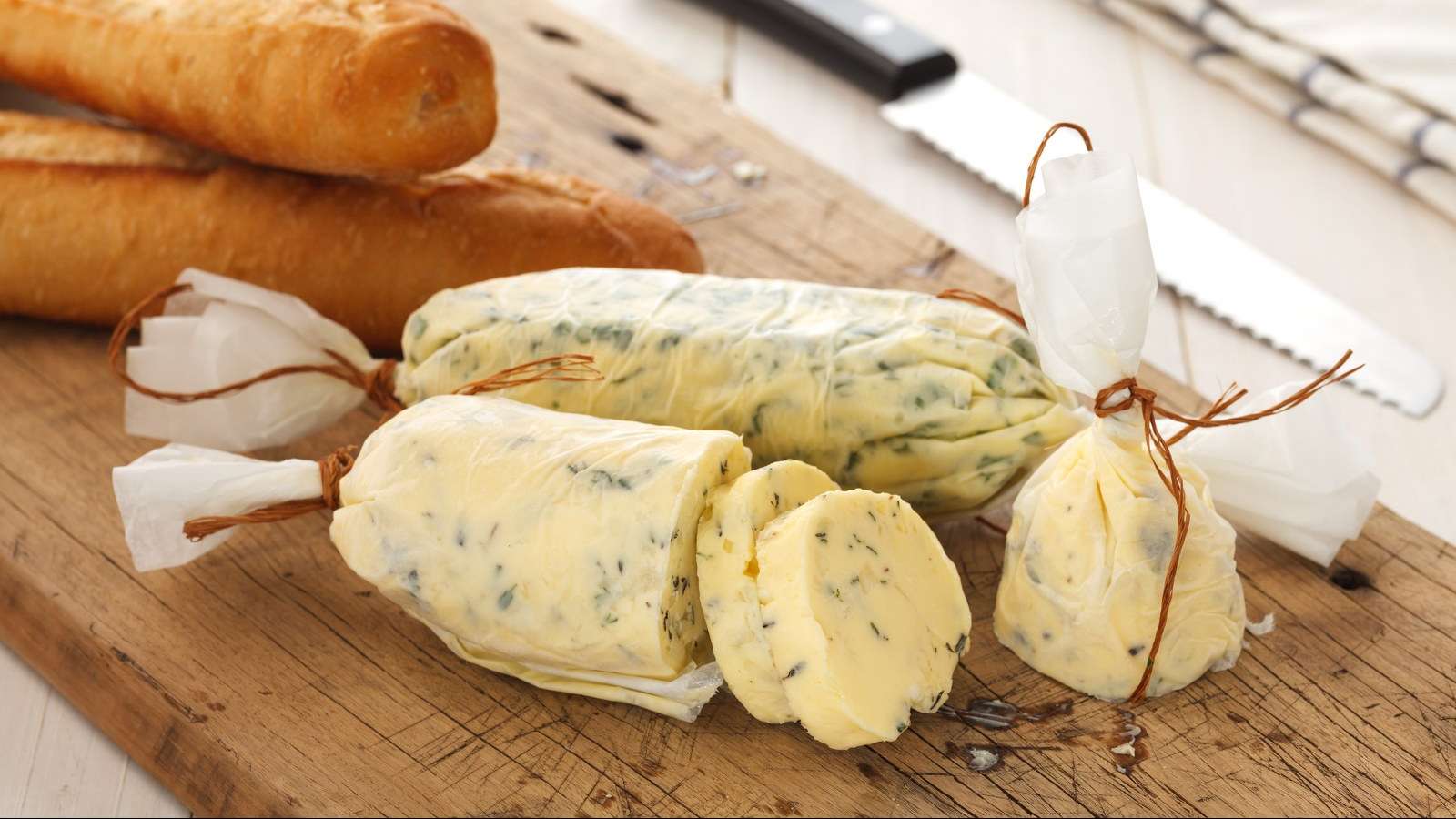 2 rouleaux de beurre composé aux herbes, accompagnés de 2 baguettes de pain