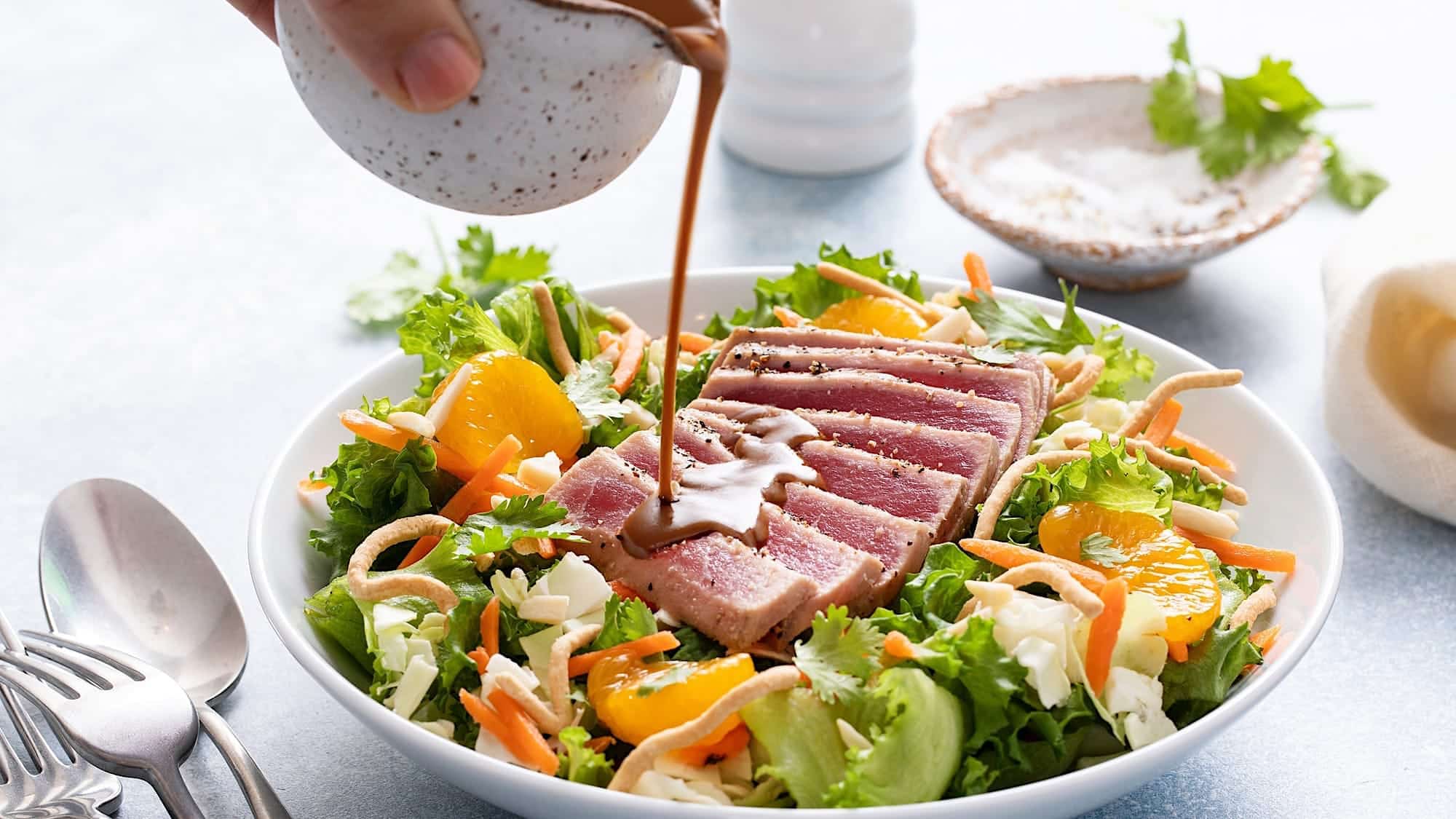 Un bol de salade asiatique avec mandarines et tataki de thon rouge pour un bol-repas léger et santé
