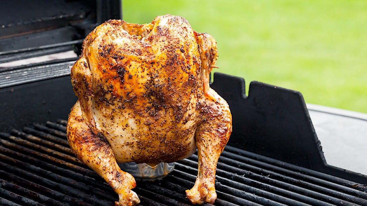 Un poulet rôti sur une canette de bière sur le BBQ