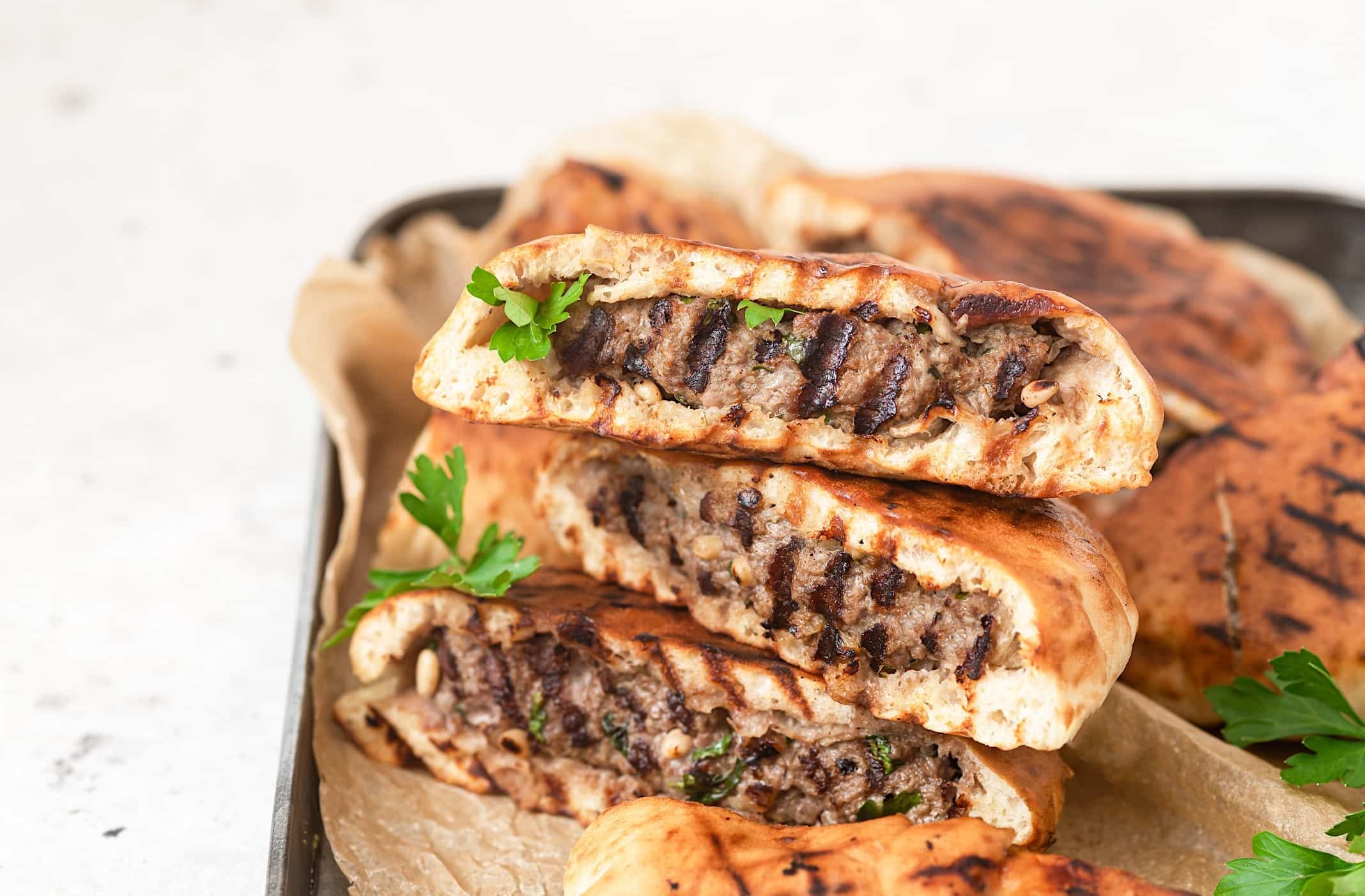 recettes-boeuf-hache-BBQ-arayes 3 morceaux de pitas farçis, aussi nommés Arayes, cuits sur le BBQ sont posés sur un plateau