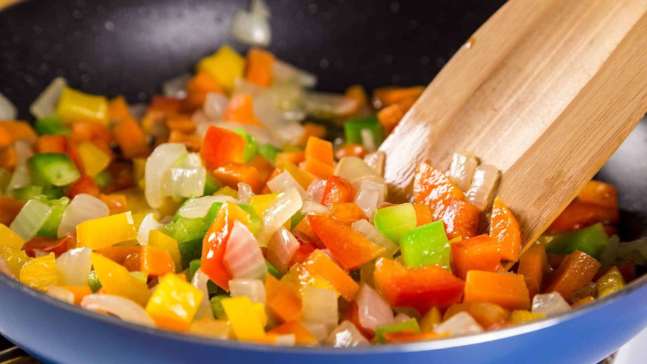 Des légumes hachés sautés à la poêle et brassés avec une cuillère en bois