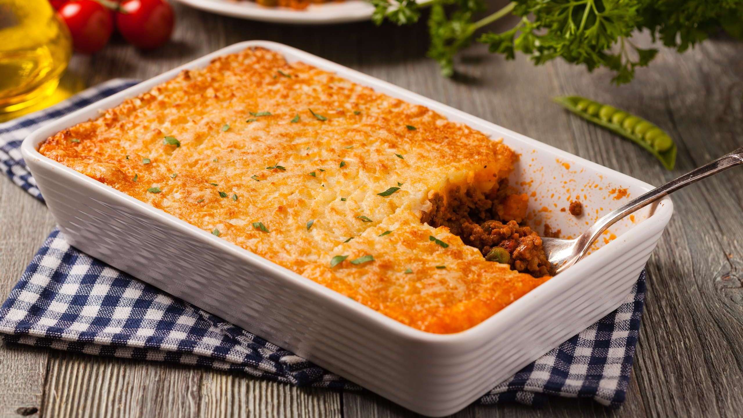 Une casserole rectangulaire contient une recette de pâté chinois de patates douces et saucisses.