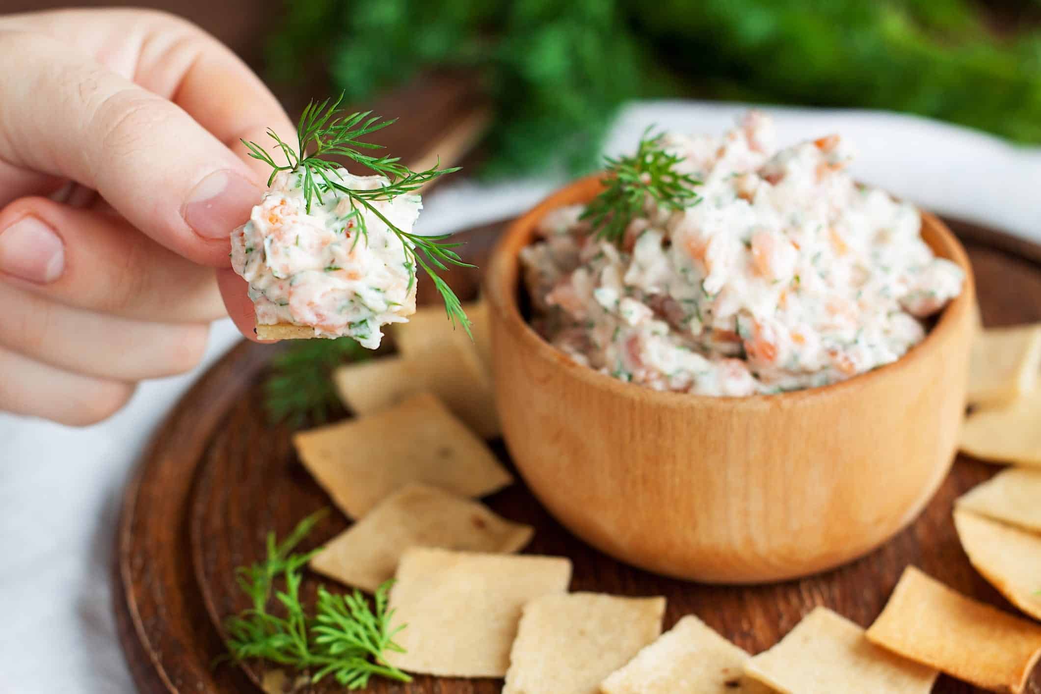 Une recette de trempette de saumon dans un bol de bois, accompagné de craquelins