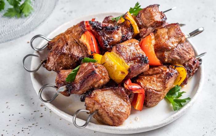 Une assiette de cubes de porc l'épicier montés en brochettes avec des légumes et cuites sur le BBQ