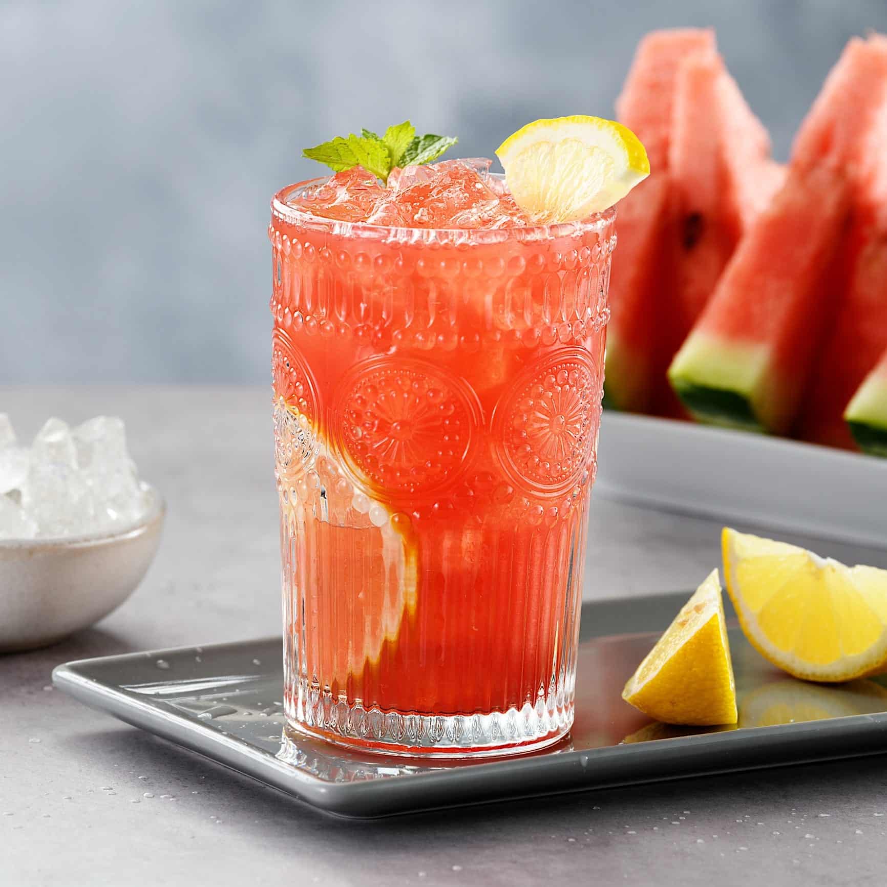 Sangria-recette-melon-deau Un verre de sangria au melon d'eau garni de citron et de menthe pour une recette de sangria rafraîchissante