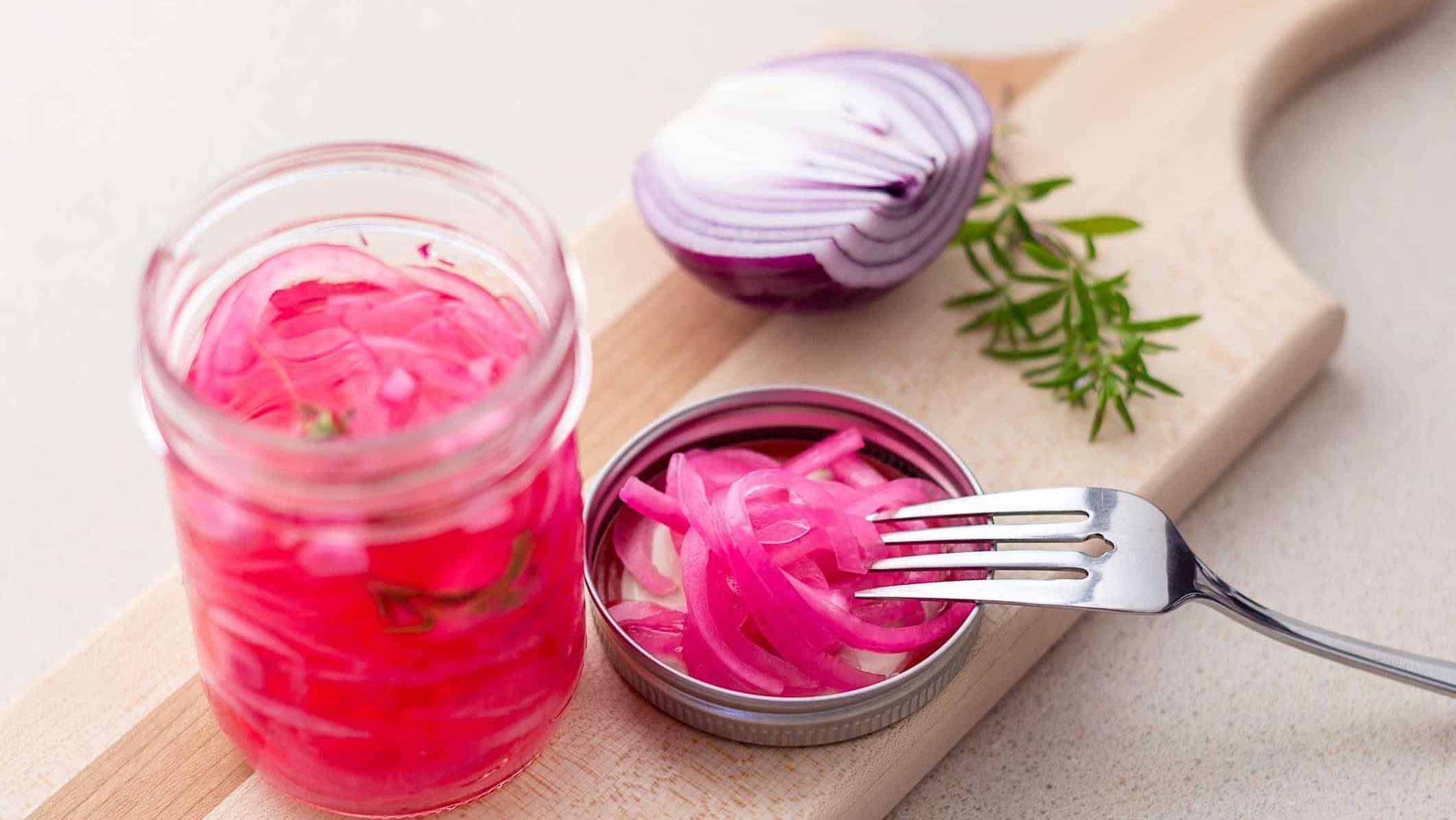 Pickle-rapides-BBQ-oignons-rouges-marinés Un pot de fines tranches d'oignons rouges marinés avec une recette de pickle rapide