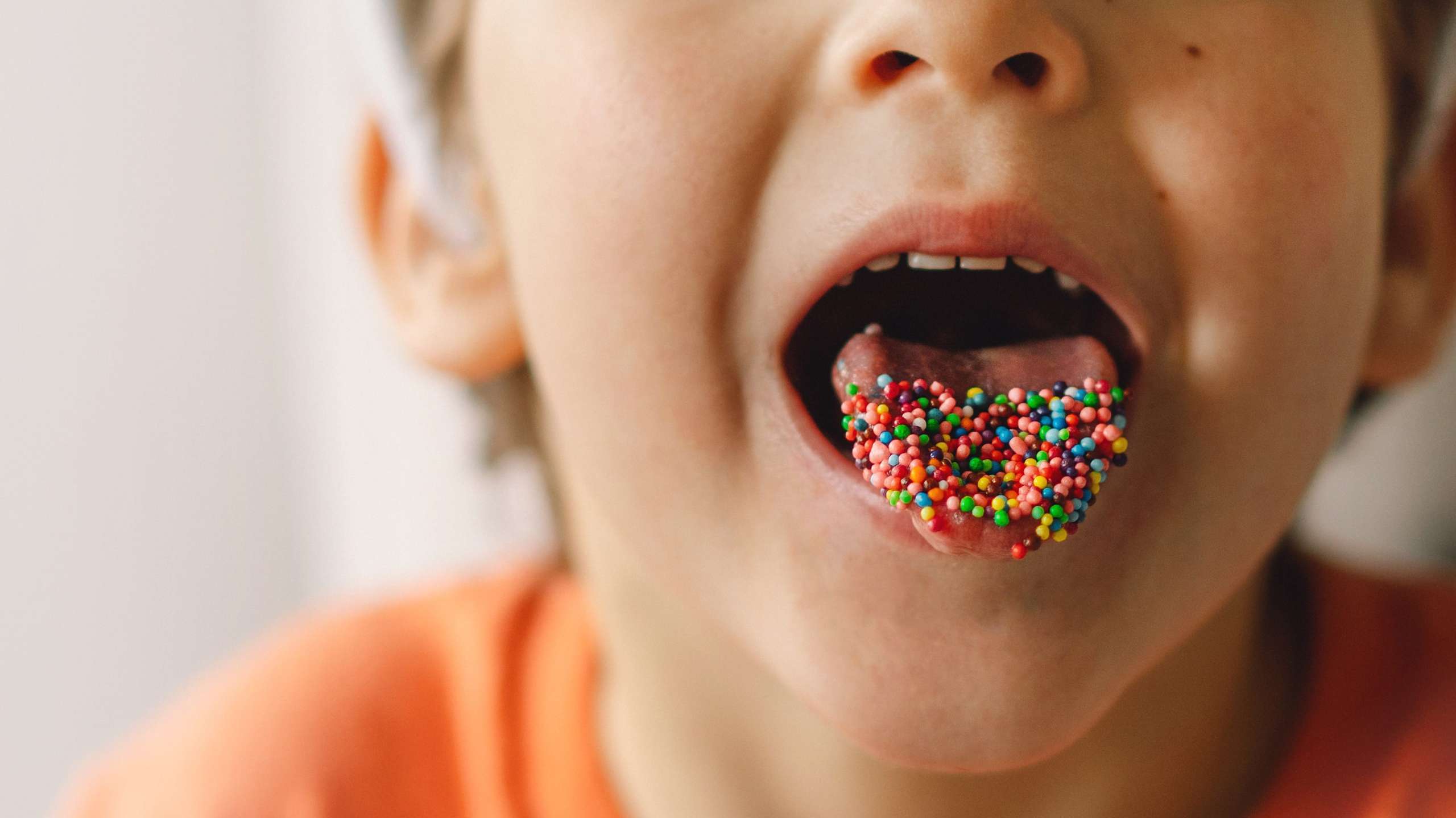 enfant-difficile-nourriture-papilles-gustatives Un enfant a la bouche ouverte et sa langue est recouverte de petites billes de bonbon