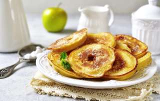 Beignets de pommes faciles cuisinés au airfryer sont posés sur une assiette blanche.