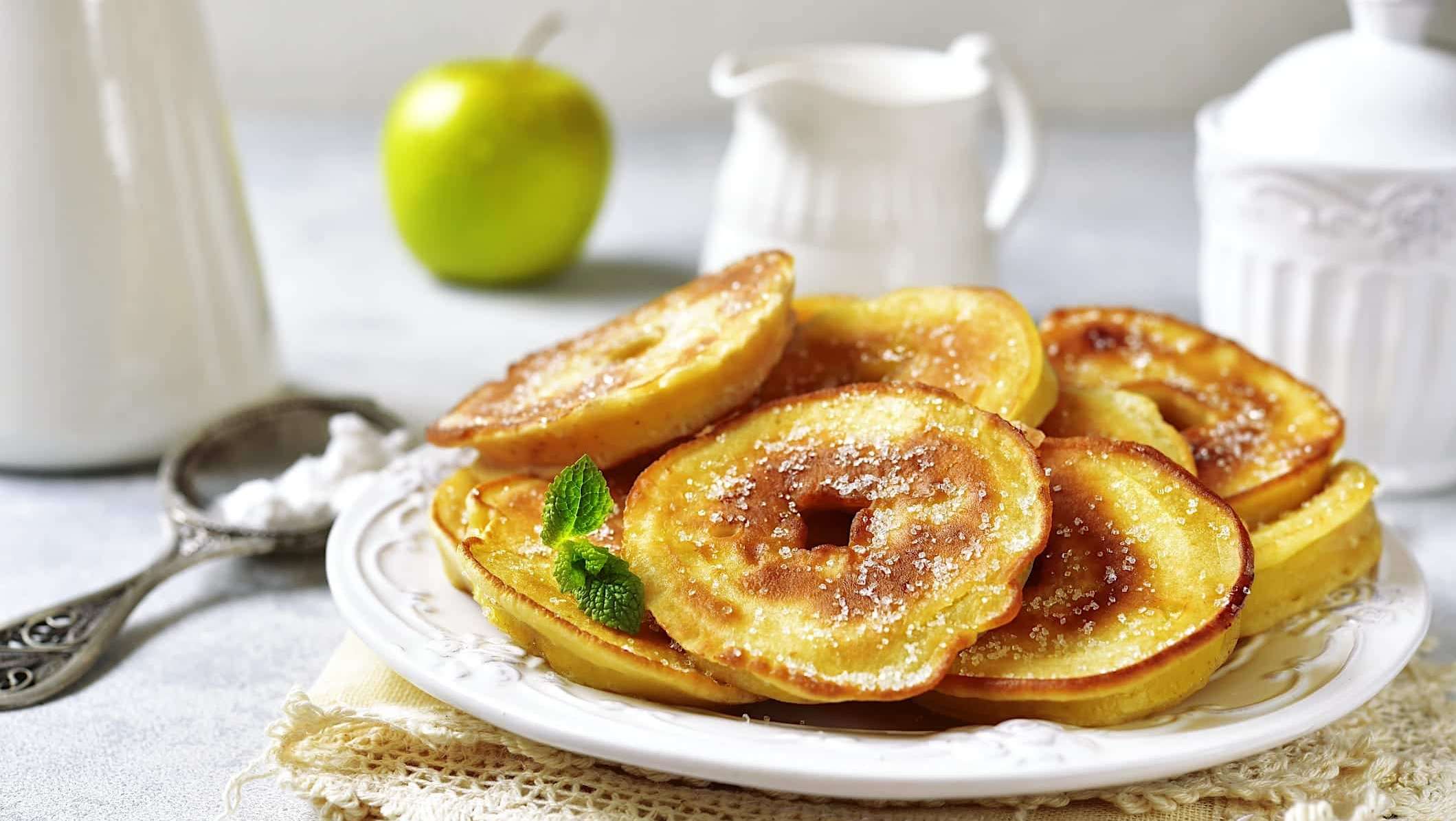 Beignets de pommes faciles cuisinés au airfryer sont posés sur une assiette blanche.