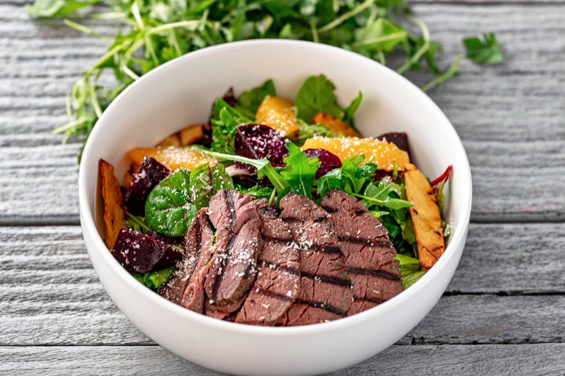 salade-hiver-proteines-boeuf_1804x1200 Un bol de salade d'hiver protéinées avec du steak de boeuf l'épicier grillé, des légumes frais, surgelés et en conserve, des oranges et de la roquette