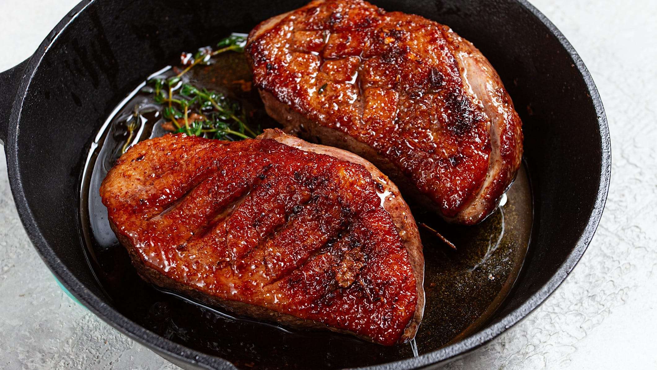Deux poitrines de canard rôties à la poêle pour illustrer des idées de repas pour remplacer la classique dinde de Noël.
