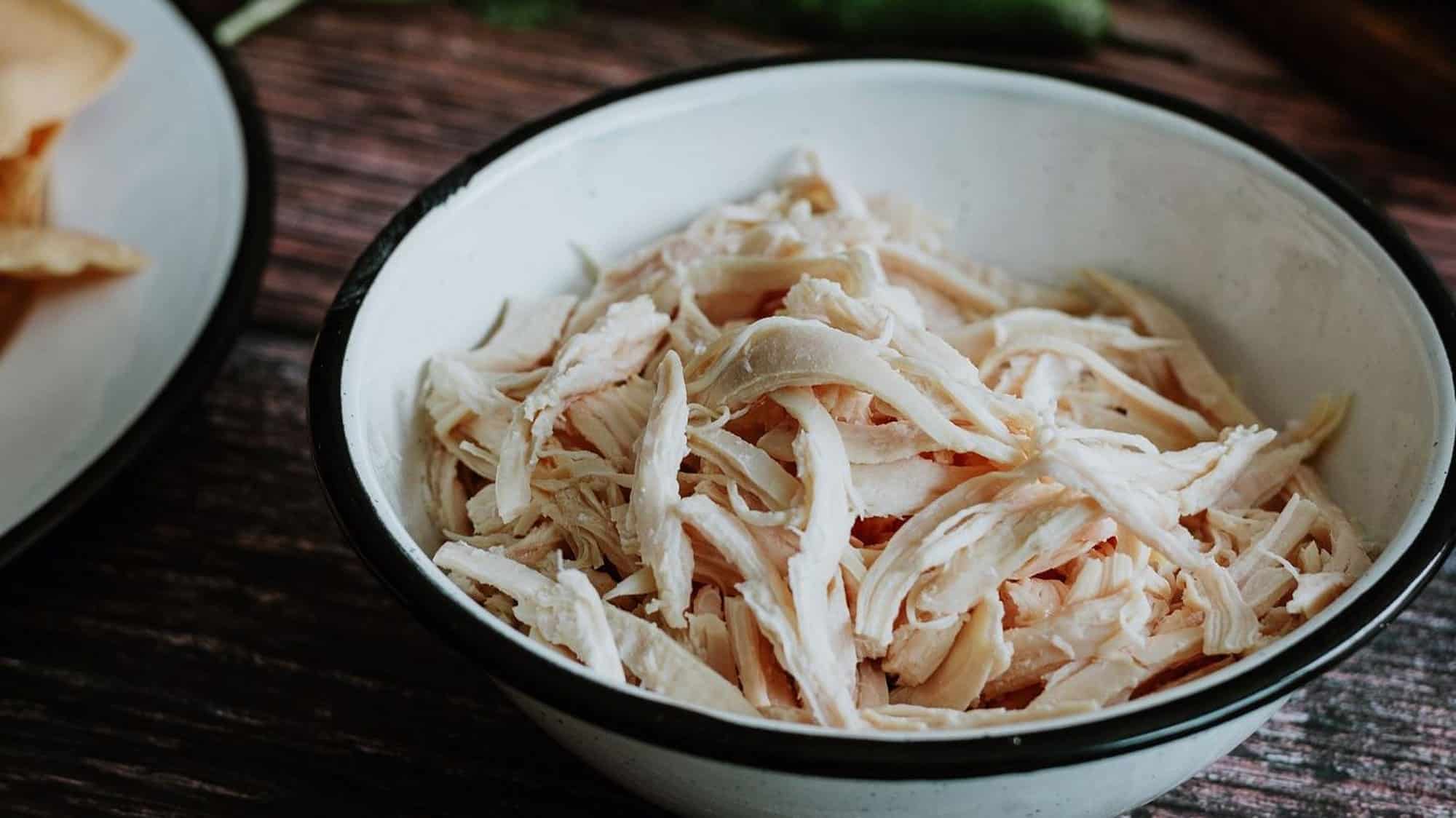 Un bol blanc à rebord noir rempli de restes de dinde du repas des fêtes