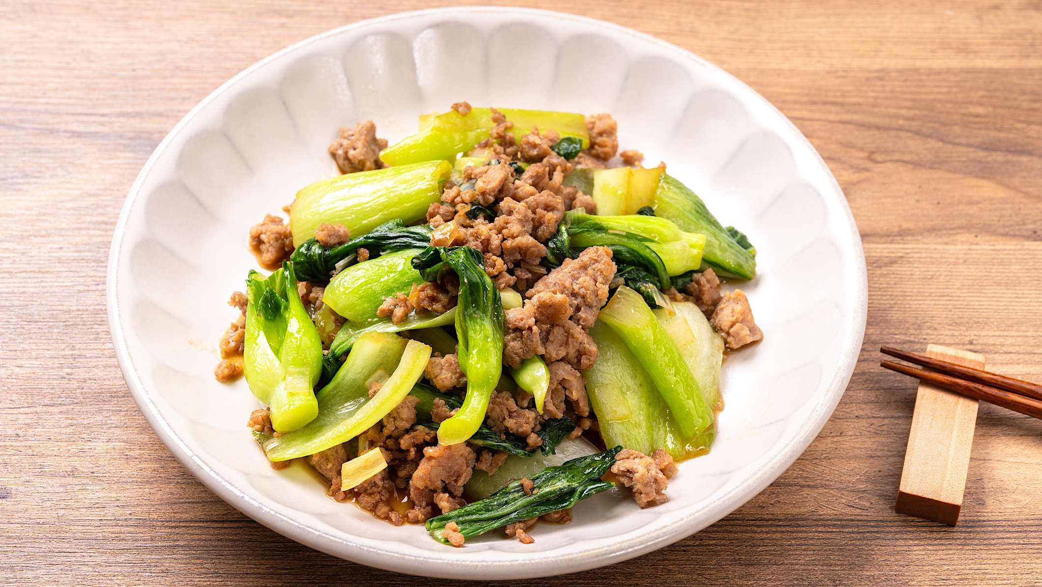 Un bol blanc contient une recette de sauté de porc haché et bok choy pour des repas de semaine rapides.